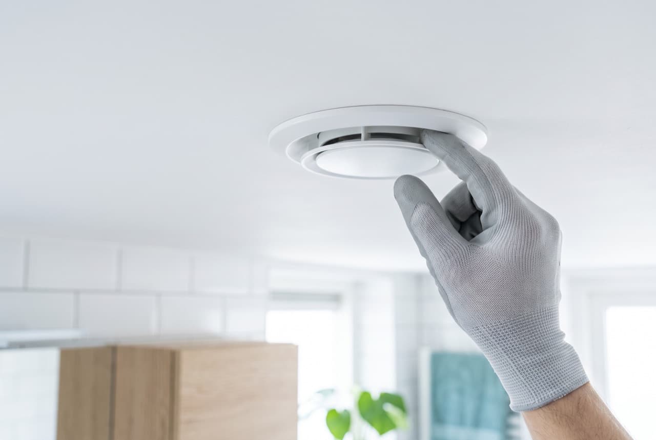Monteur stelt een ventilatieventiel in het plafond af