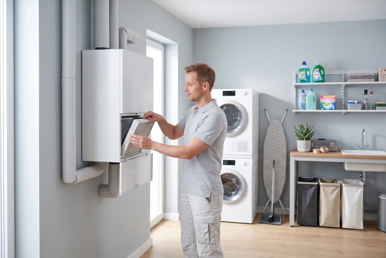Monteur controleert het filter van een WTW-ventilatie-unit